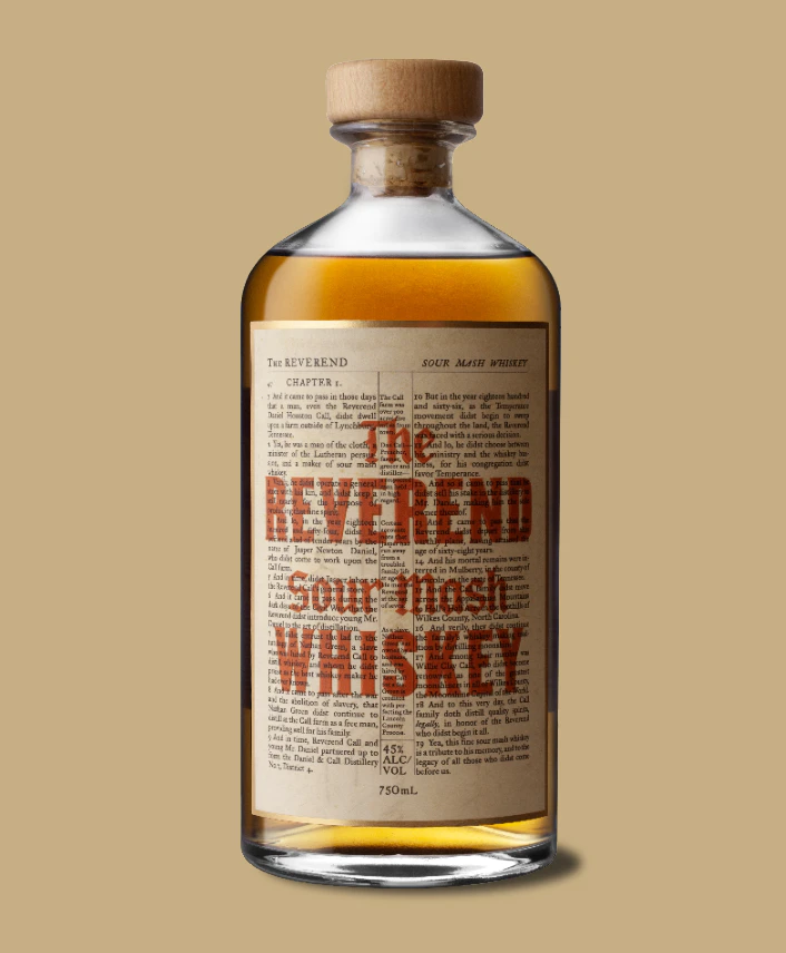 A bottle of The REVEREND Sour Mash WHISKEY isolated on a on a tan background